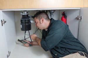 a man working under a kitchen sink